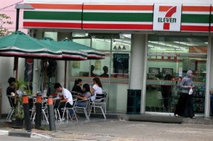 During daylight: People sit at tables in front of one of Jakarta’s 7-Eleven convenience stores. JP/Nurhayati